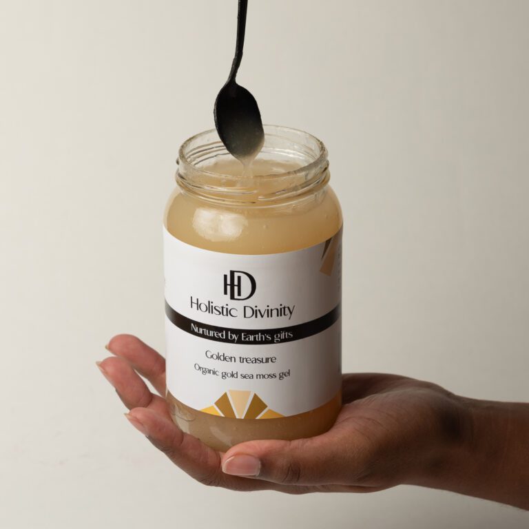 Golden Treasure | Organic Gold Sea Moss Gel | Holistic Divinity | Open jar of gold seamoss held in hand with black spoon coming out