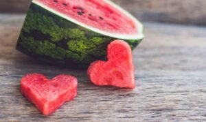 Watermelon cut into a quarter with two heart cut outs of watermelon