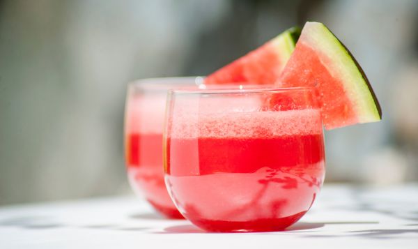 Watermelon juice in two glasses with a triangle of watermelon on each glass for decoration